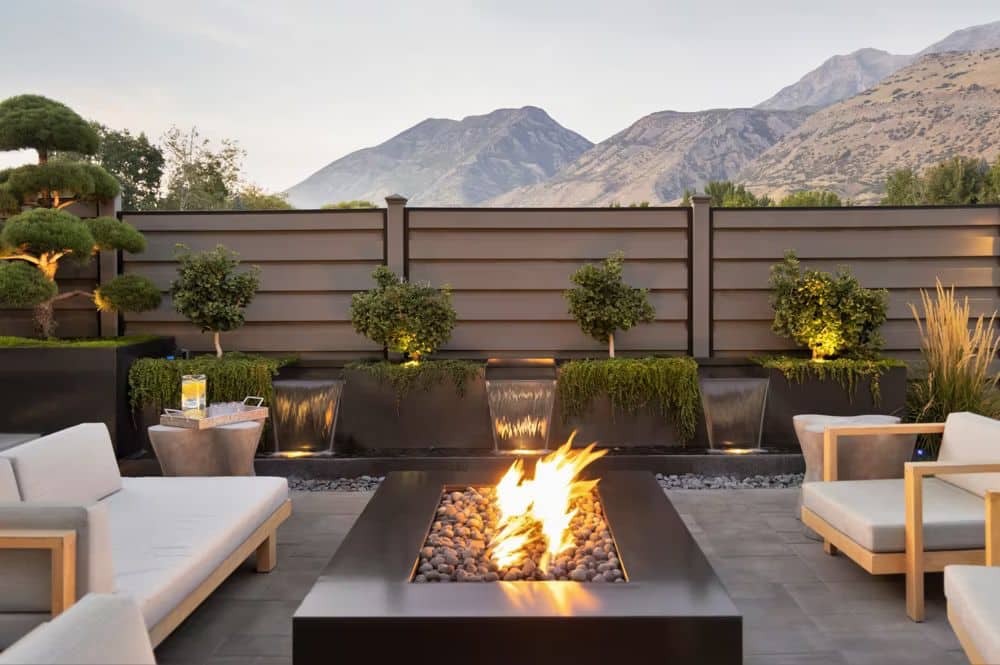 A cozy patio featuring a fire pit surrounded by chairs, designed by Innovative Fencing for outdoor relaxation.