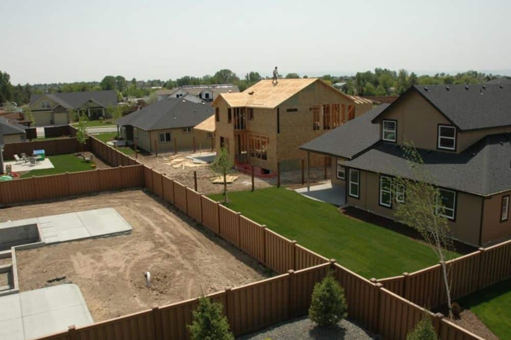 A serene backyard view showcasing a fence and houses, highlighting the charm of Neighborhood Aesthetics.