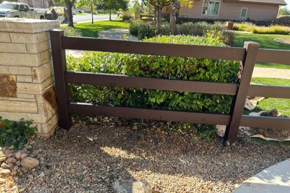 A brown modern farmhouse fence replaces an old wooden fence showcasing modern fence designs.