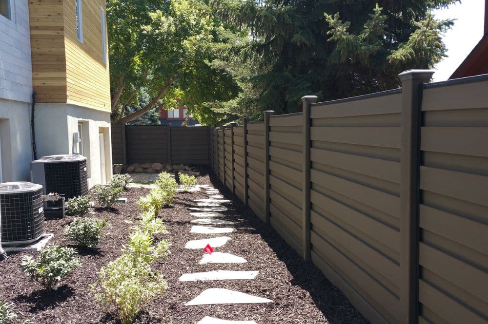 Backyard with plants and a fence, showcasing rental property fencing for privacy and aesthetics.